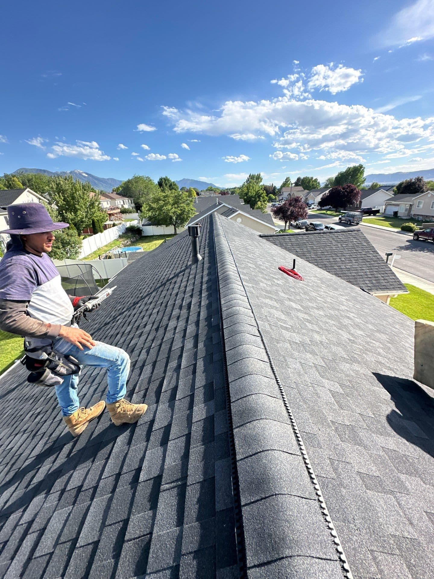 A Robinhood rep on a finished roof above a Utah neighborhood